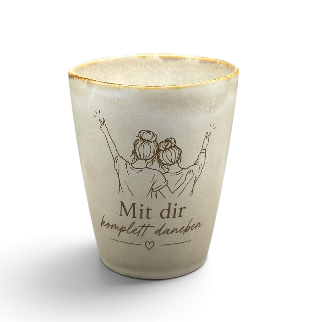 Beiger Keramikbecher ohne Henkel mit Gravur „Mit dir komplett daneben“ und Freundinnen-Motiv