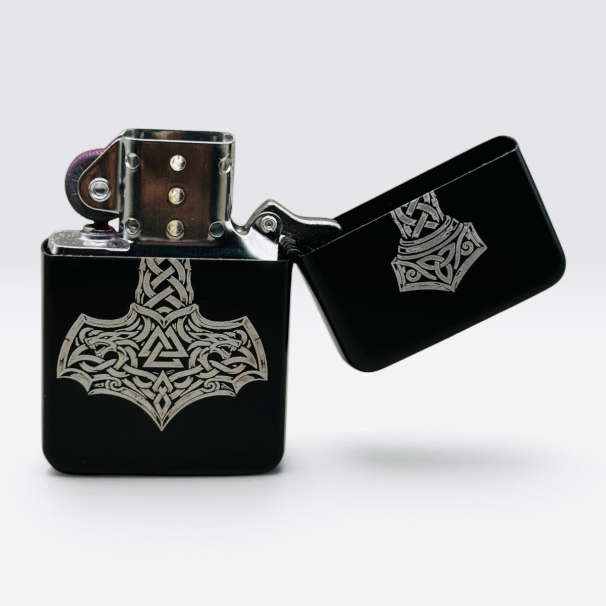 Geöffnetes schwarzes Benzinfeuerzeug mit Thors-Hammer-Gravur (Mjölnir) und Reibradzündung