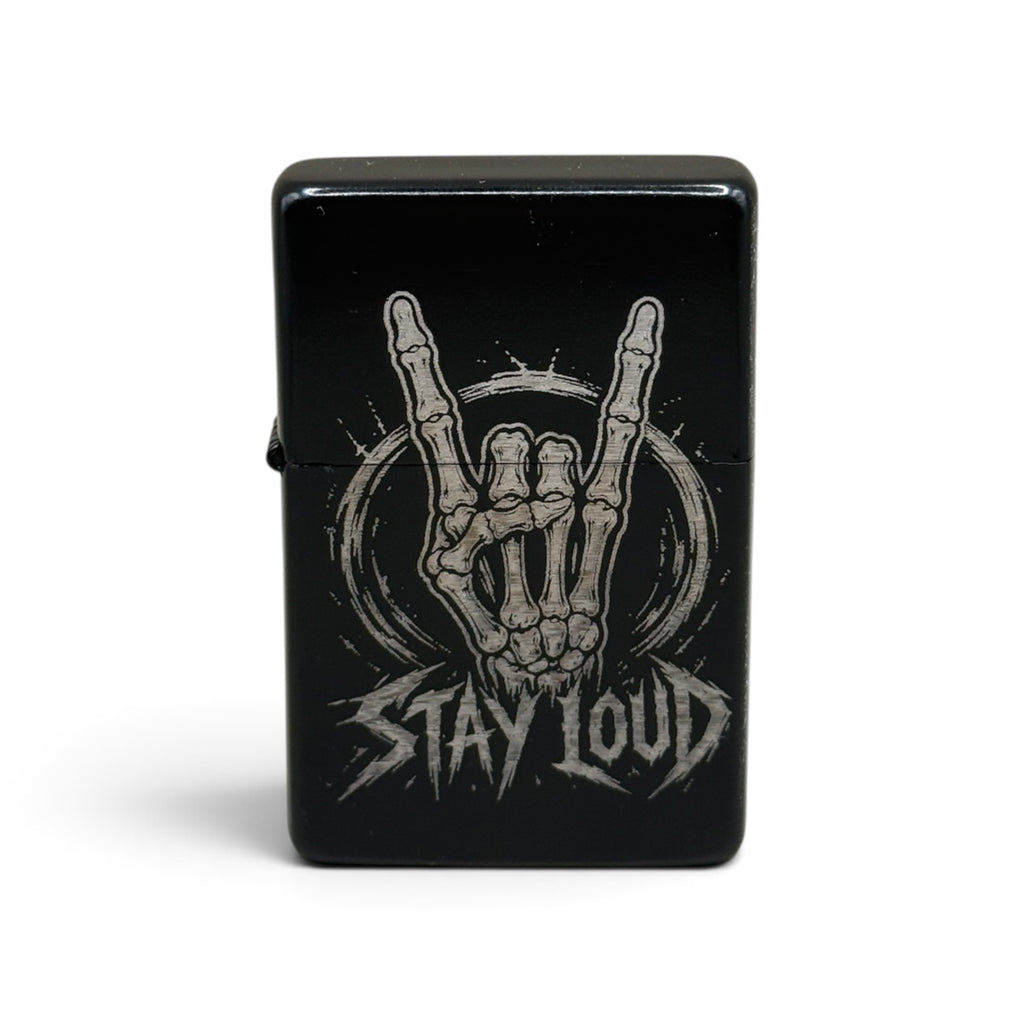 Schwarzes Benzinfeuerzeug mit Stay-Loud-Gravur und skelettiertem Metal-Handzeichen, Frontansicht