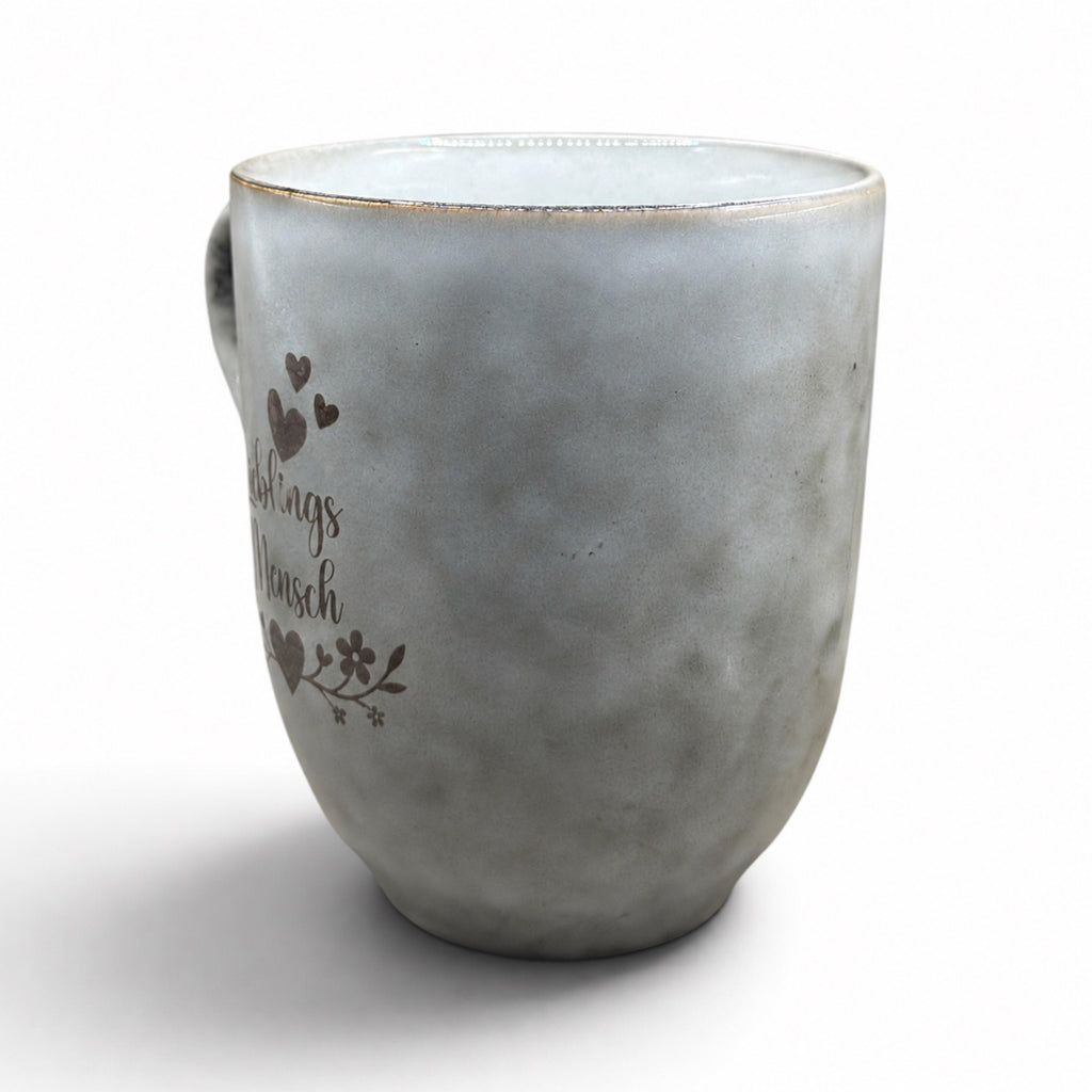Graue Keramiktasse mit floralem Lieblingsmensch-Motiv in Seitenansicht