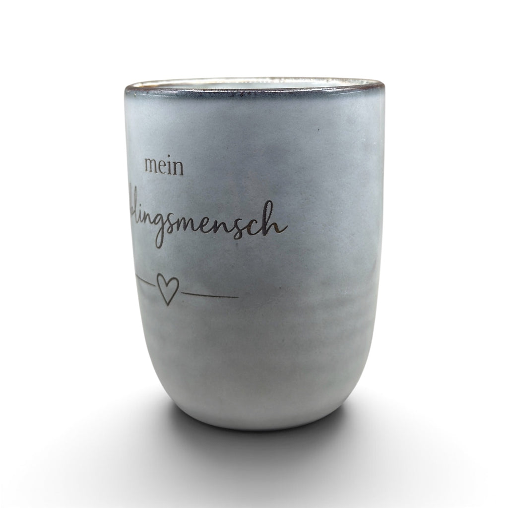 Graue Keramiktasse mit graviertem Lieblingsmensch-Motiv in schräger Ansicht