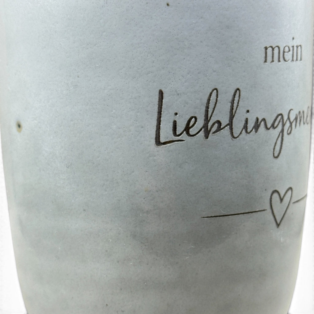 Detail der Lasergravur „Mein Lieblingsmensch“ mit Herzmotiv auf grauer Keramiktasse