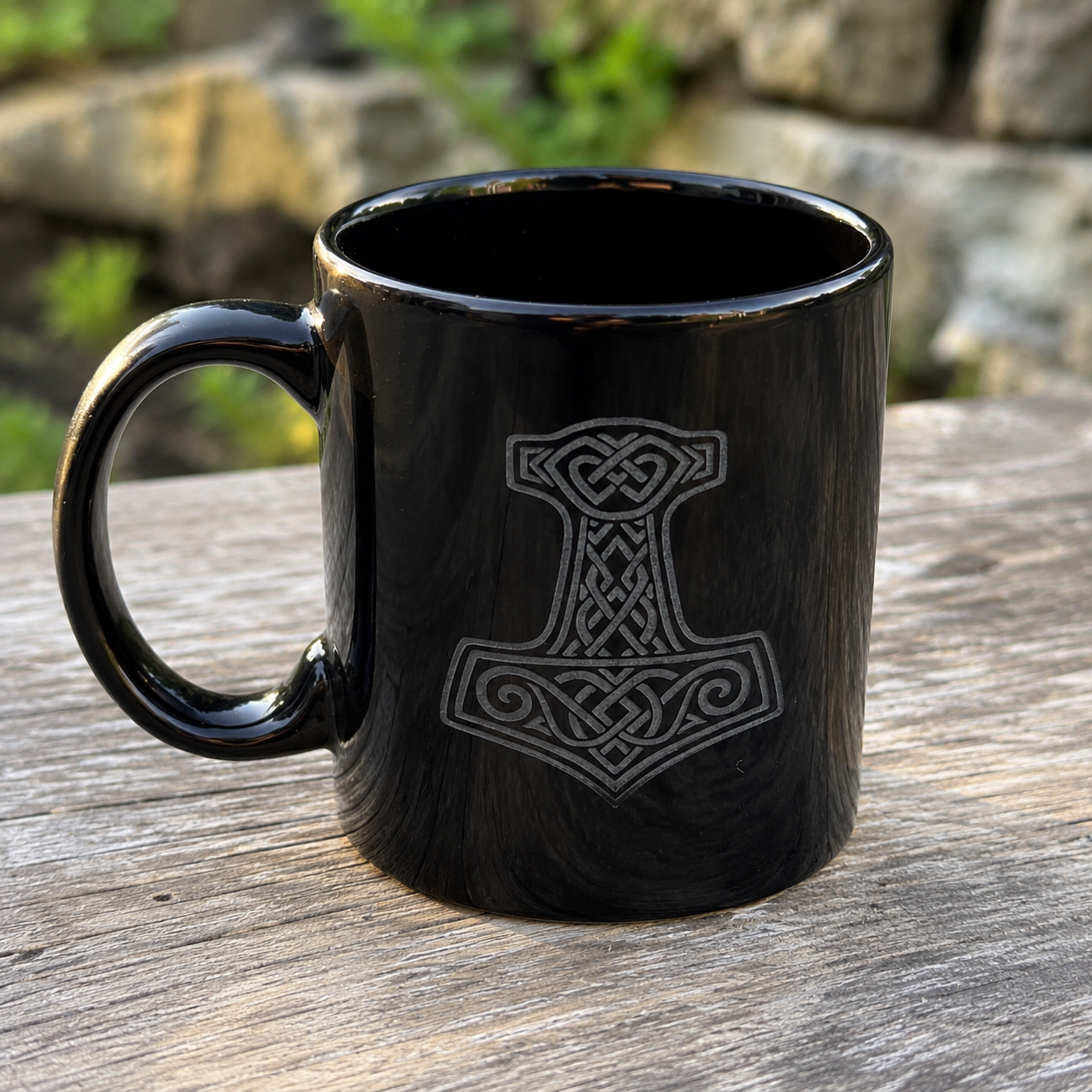 Schwarze Keramiktasse mit Mjölnir Gravur aus der nordischen Mythologie in Seitenansicht