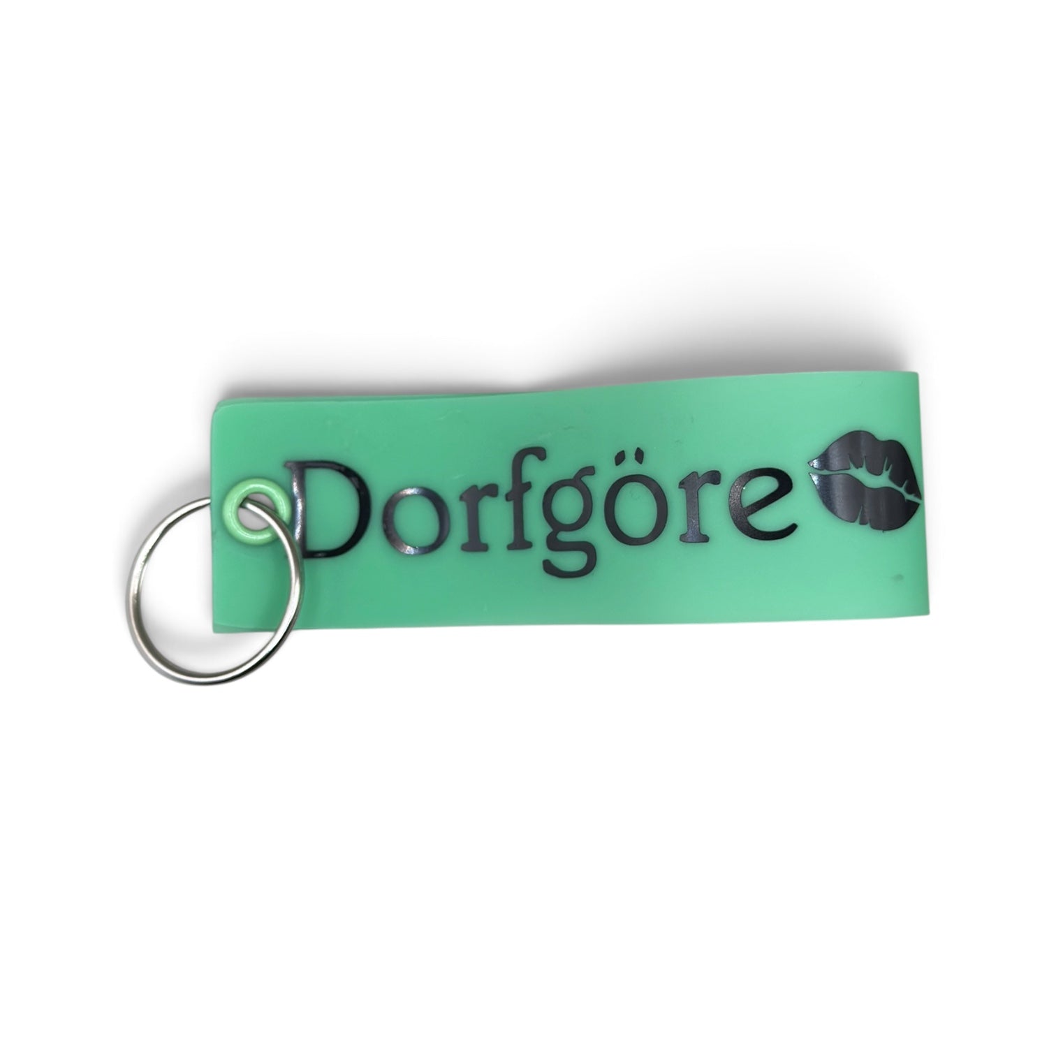 Grüner Vinyl-Schlüsselanhänger mit Aufschrift „Dorfgöre“ und Lippenmotiv